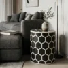 Decorative black bone inlay round side table in modern living room with decor items and books