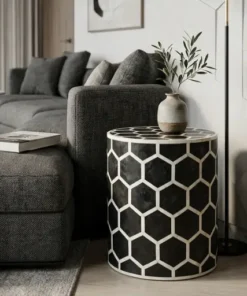 Decorative black bone inlay round side table in modern living room with decor items and books