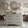 Luxurious grey mother of pearl inlay floral design four drawer chest placed in luxury living room with decorative wall mirror, lamps, and other decor items