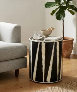 Handmade black bone inlay zigzag pattern side table in modern living room with grey sofa and plant
