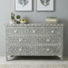 Grey mother of pearl 7 drawer chest dresser is handcrafted with detailed shell inlay work and placed in living room with decor items