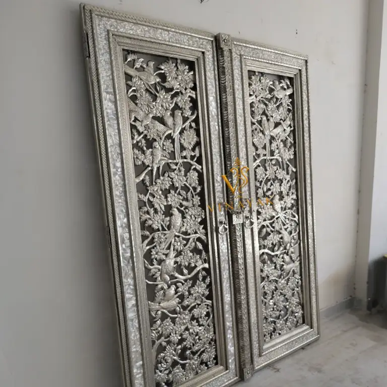 Intricate floral and bird design on a handcrafted German silver temple door panel